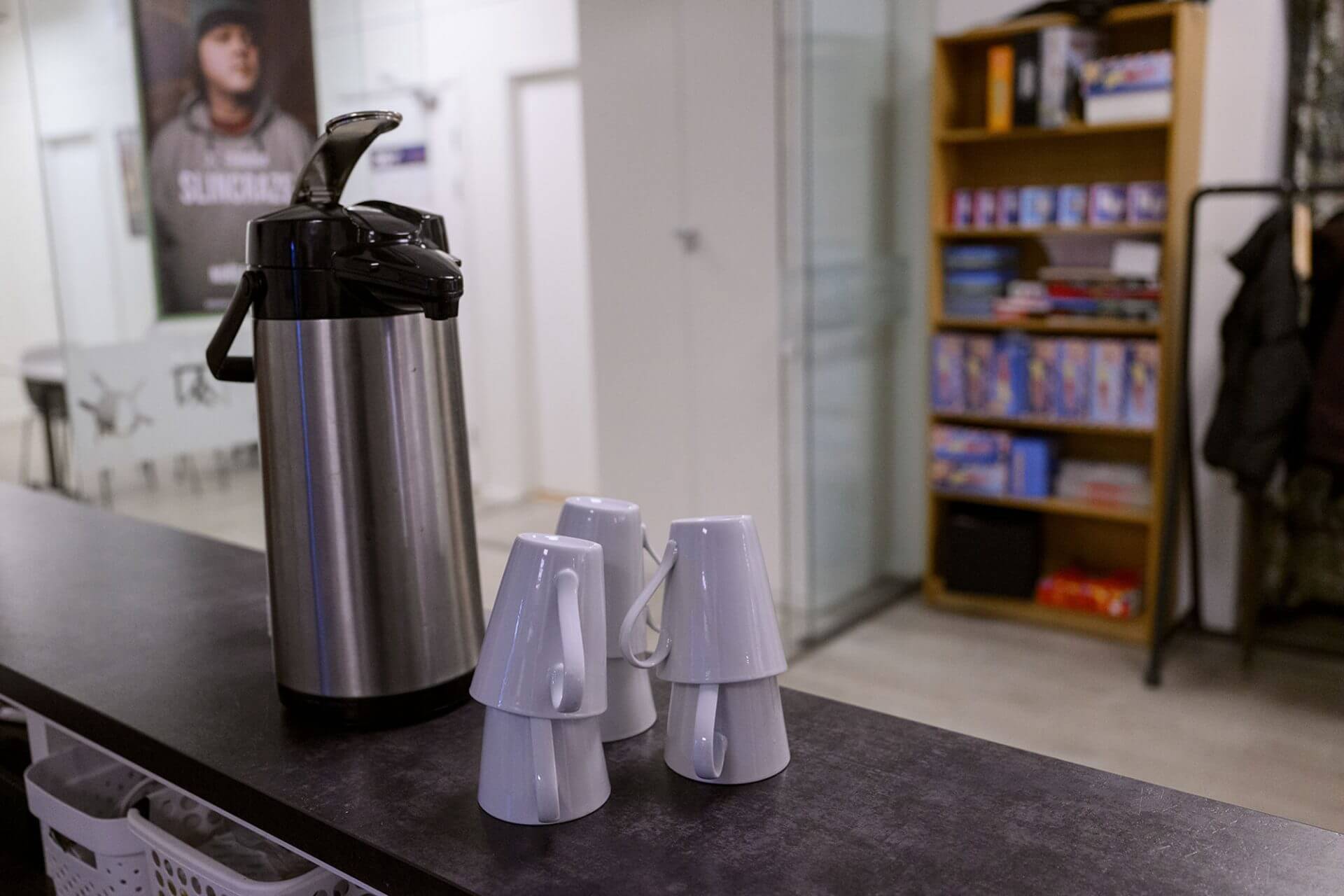 Kaffekanne og kaffekopper på en disk.